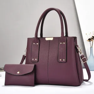Detailweergave van donkerpaarse lederen schoudertas set met grote handtas en bijpassende clutch tas.