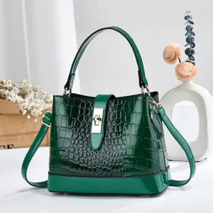 Détail du sac seau en cuir verni vert gaufré crocodile avec élégant fermoir cadenas doré.