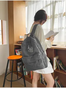 Detailed view of grey plaid student backpack with letter embroidery for casual daily school use.