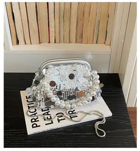 Detailed shot of the silver sequin evening bag with elegant pearl handle and chain.