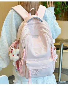 Vista dettagliata dello zaino rosa con delicati ricami e simpatico ciondolo coniglio in peluche.