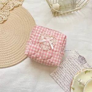 Pink gingham quilted cosmetic bag with lace heart bow detail, cute makeup pouch for daily storage.