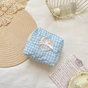 close up detail of blue white plaid quilted makeup pouch with cute lace heart bow.