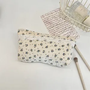 Detaillierte Kosmetiktasche mit Blumenmuster und feiner weißer Spitzenverzierung im Detail.