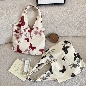 Vue détaillée du sac cabas en toile avec broderie de papillons pour les loisirs quotidiens.
