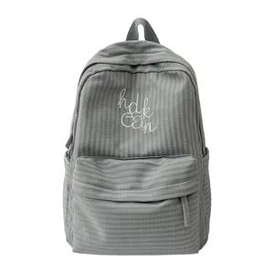 Grey grid backpack detail featuring front zipper pocket, white embroidery text, and top handle.