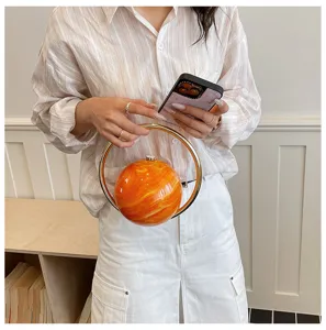 Acryl bal avondtas met opvallende oranje marmeren afwerking en gouden ringhandvat.