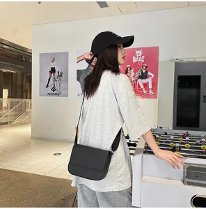 Vista dettagliata di una borsa a tracolla minimalista in PU nero, ideale per viaggi e lavoro.