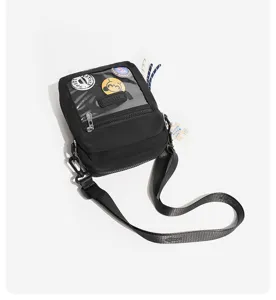 Detailansicht der schwarzen Nylon Ita Tasche mit transparentem Sichtfenster und coolen Badges.