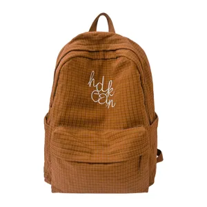 Detailed view of brown grid backpack with front embroidery, stylish student school bag.