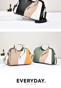 Detailed view of the stylish color-blocked handbag with a unique metal handle and smooth leather.