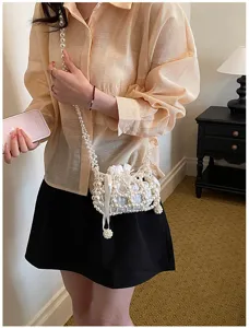 Nahaufnahme der eleganten handgefertigten Perlen-EimerTasche mit weichem Kordelzugbeutel.