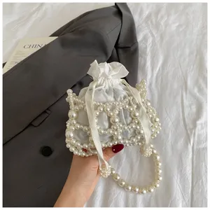 Exquisites Detail einer weißen Perlen-Eimer-Tasche, gewebte Umhängetasche mit Hohlmuster.