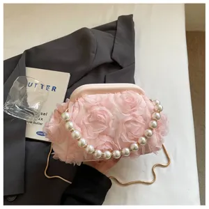 Pink rose flower kiss lock evening bag with pearl handle and fine metal chain detail.