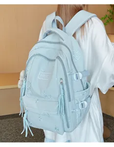 Vista dettagliata dello zaino da studente azzurro con ricami delicati e tasche laterali.