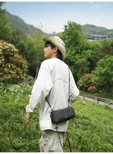 Vista detallada de estilo de vida al aire libre con bolso bandolera a cuadros negros.