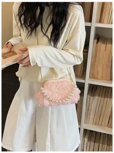 Exquisite pink floral crossbody bag detail featuring elegant pearl handle and gold chain.