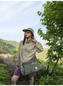 Detailed shot of casual nylon messenger bag in outdoor setting with model wearing it.