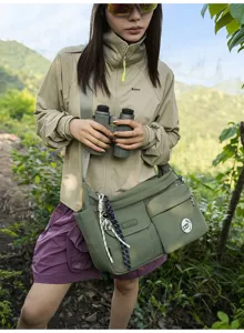 Detailed view of the casual nylon messenger bag with multi-pockets and cool astronaut charm.