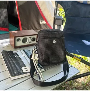 Detail view of the black plaid small crossbody bag, stylish neutral shoulder bag for outdoor travel.
