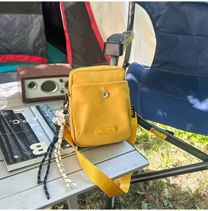 Outdoor casual yellow crossbody bag detail shot featuring multi-pocket design and strap.