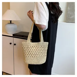 Vue détaillée du sac cabas en paille tissée à la main avec bandoulière élégante.