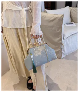 Dettaglio borsa da sera vintage cinese ricamata con chiusura a bacio, elegante tracolla a catena.