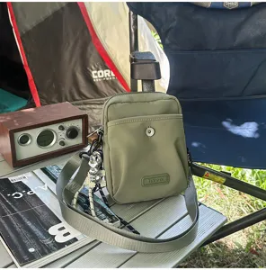 Casual green canvas crossbody shoulder bag for outdoor travel and daily commute, compact styling.