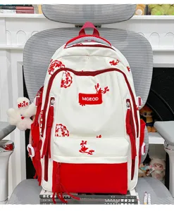Dettaglio dello zaino scolastico ricamato in stile cinese con tasche rosse e bianche.