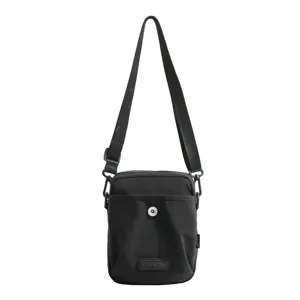Black crossbody bag detail, featuring adjustable shoulder strap and front pocket with snap.