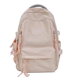 Primo piano dettagliato dello zaino studentesco rosa con delicati ricami e nappe.
