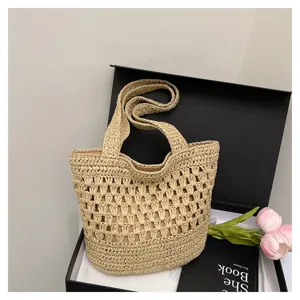 Vue detaillee du sac cabas en paille tresse main avec texture delicate et design elegant.