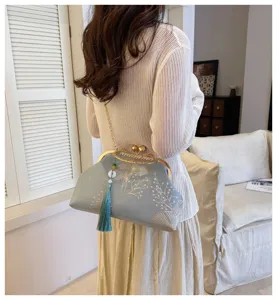 Vista dettagliata della borsa a pochette ricamata in stile cinese vintage con cornice e nappa.