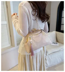 Elegante borsa da sera retrò ricamata con chiusura metallica a scatto e nappa decorativa.