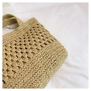 Vue détaillée du tissage en paille fait main et ajouré, montrant une texture fine et un ton beige.