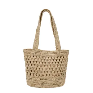 Vue détaillée du sac cabas en paille ajourée avec tissage crocheté et anses solides.