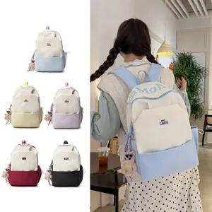 Large capacity student school backpack with stylish color blocking and cute bear pendant.
