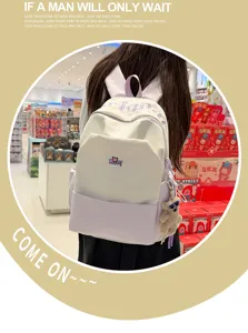 Detailed view of the stylish contrast backpack featuring cute bear pendant and spacious design.