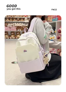 Detail view of a large capacity color block canvas backpack with cute doll pendant and pockets.