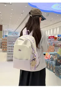 Stylish color-blocked student backpack with chic letter embroidery and cute bear pendant.