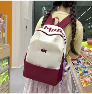 Large capacity color-blocked student backpack with letter embroidery and cute pendant for daily school.