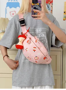 Vue détaillée du sac rose avec imprimé de pommes et pendentif cœur de pomme en peluche.
