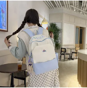 Stylish color-blocked student backpack with letter print and cute bear pendant for daily use.