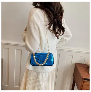 Detailansicht der blauen Acryl Abendtasche mit Perlenkettenriemen, elegantes Design.