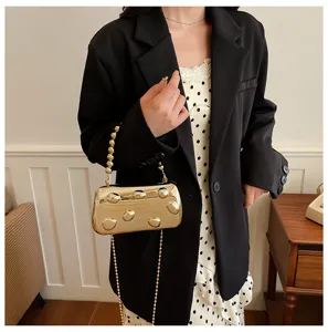 Goldene Metallic-Clutch-Detailansicht, Abendhandtasche mit Perlenkettenriemen und runden.