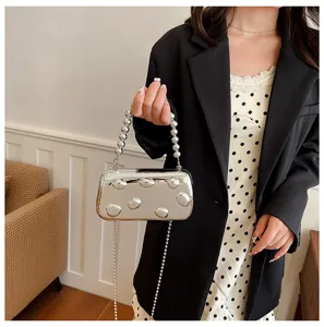 Silberne metallische Hartschalen-Abendtasche mit Perlenhenkel und Kette für elegante Damen.