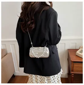 Detailansicht der eleganten silbernen Abendtasche mit großen Perlen und Metallkette.