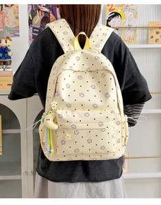 Cute star print nylon student backpack detail view, featuring front pocket and charms.