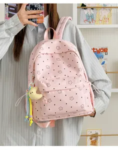 Detail view of the pink nylon student backpack with cute star patterns and front pocket.