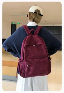 Detailansicht eines stilvollen Vintage-Rucksacks aus Cord mit niedlicher Schleife in Weinrot.